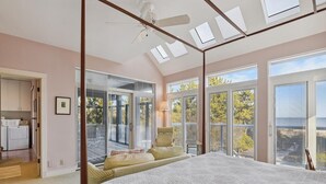 Un dormitorio con una cama grande, ventanas de tragaluces y vistas al exterior.