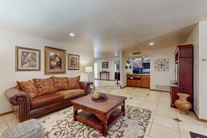 A living room with a brown leather sofa, a wooden coffee table, and a patterned rug. - 4 BR house with pool, putting green, great patio (Scottsdale)