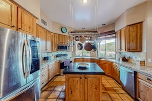 Una cocina moderna con armarios de madera, electrodomésticos de acero inoxidable y una isla grande.