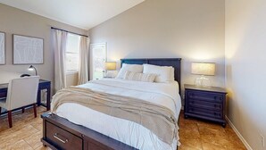 Ein Schlafzimmer mit Bett, Nachttischen, Schreibtisch und Stuhl.