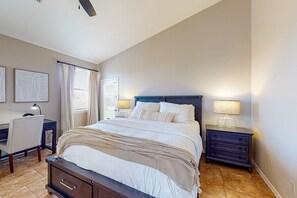 Ein Schlafzimmer mit Bett, Nachttischen, Schreibtisch und Stuhl.