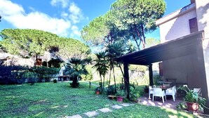 A garden with a patio area, potted plants, and a pathway. - Villa Prestige 🌊✨ - Refinement and Relaxation Just a Step from the Sea (Santa Margherita di Pula)