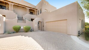 A modern building with a garage, a staircase, and a paved driveway. - Lovely, Ground-Floor Townhouse with a Great Location, Patios, WiFi & Shared Pool (Carefree)