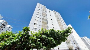 A tall white building with multiple balconies and a clear blue sky. - COAPI0100 - Edificio Palais Atlantique (Salvador)