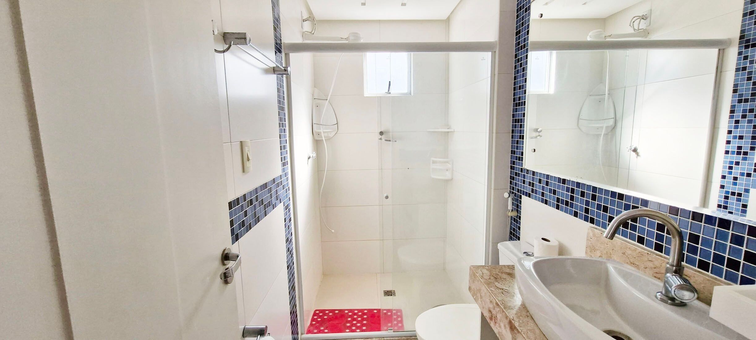 A bathroom with a shower, toilet, and sink.