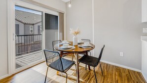 A dining area with a round table, four chairs, and a vase with flowers. - Charming Condo with Central A/C & Washer/Dryer - Shared Pool & Hot Tub (Phoenix)