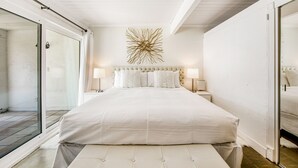 A bedroom with a large bed, a glass shower enclosure, and a ceiling fan. - Appealing Racquet Club home with firepit, private pool & gas grill (Palm Springs)