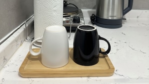 Un plan de travail de cuisine avec une machine à café, une bouilloire et un rouleau d’essuie-tout.
