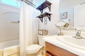 A bathroom with a toilet, a sink, a mirror, and a shower curtain. - Classy house near trails with pools, playground, basketball & beautiful upgrades (Gilbert)