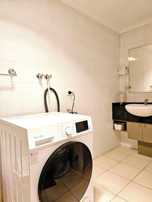 Een haardroger, handdoeken, zeep, toiletpapier