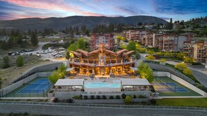 A hotel with a central courtyard, outdoor pool, tennis courts, and mountain views. - Peaceful Garden Retreat with Family & Resort Amenities (West Kelowna)