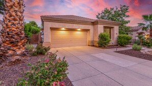 A residential house with a garage, surrounded by landscaping and a palm tree. - Snowbird-Friendly Home with Private Pool, Grill, AC, Fireplace, & WiFi - Dogs OK (Glendale)