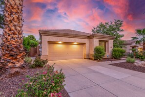 A residential house with a garage, surrounded by landscaping and a palm tree. - Snowbird-Friendly Home with Private Pool, Grill, AC, Fireplace, & WiFi - Dogs OK (Glendale)