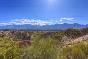 A mountainous landscape with sparse vegetation and a clear sky.