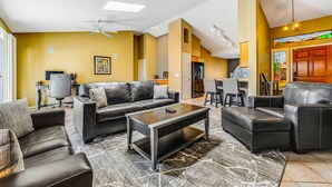 Ein stilvolles Wohnzimmer mit einer Couch, einem Couchtisch und einem Deckenventilator.