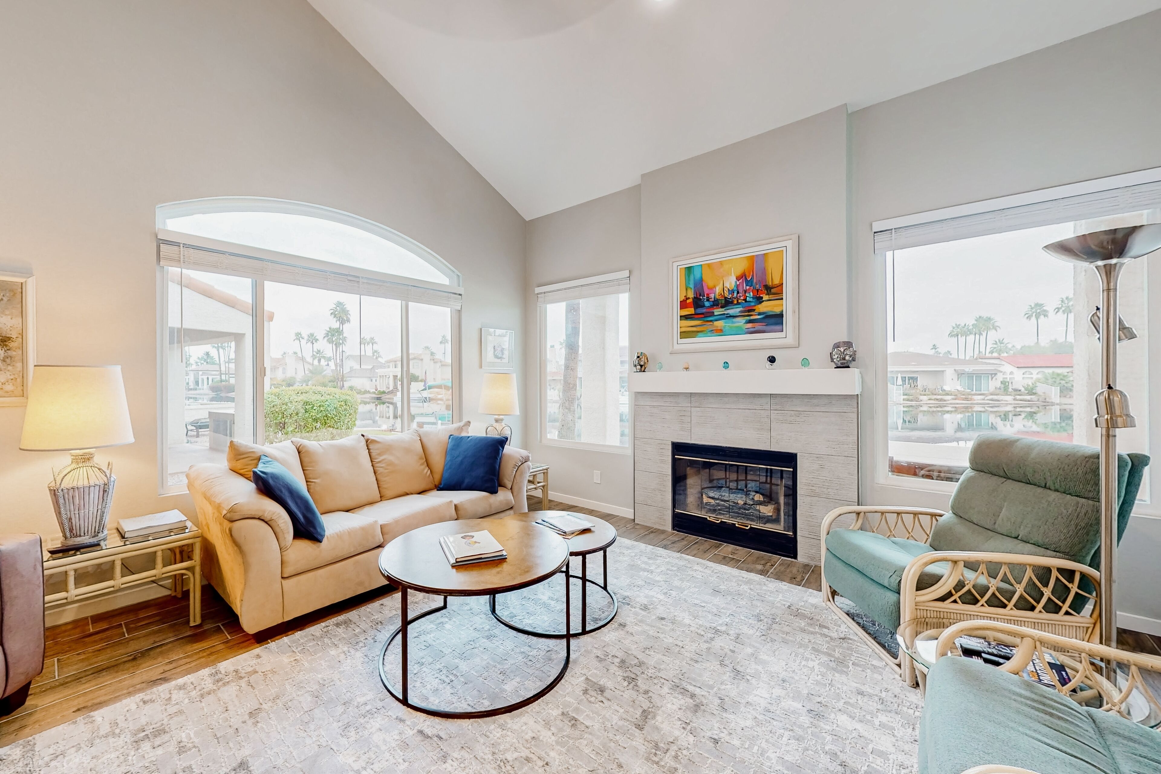A living room with a fireplace, a sofa, a coffee table, and a wicker chair.