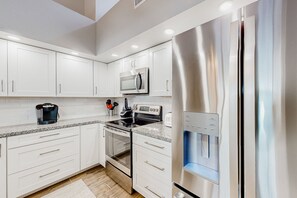 A modern kitchen with white cabinets, stainless steel appliances, and a built-in water dispenser. - Lake view desert stay with pool, patio, grill, & smart TVs - snowbird-friendly (Gilbert)