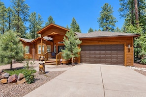 A log cabin with a garage, a porch, and a welcome sign. - Dog-friendly forested home with wraparound deck, pool table (Pinetop)