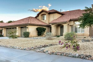 A two-story house with a tiled roof, a garage, and a landscaped front yard with rocks and plants. - Mountain view home with pool, spa and dog friendly (La Quinta)