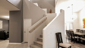 Ein modernes Interieur mit Treppe, Essbereich und Küche.