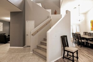 A modern interior with a staircase, a dining area, and a kitchen. - Mountain view home with pool, spa and dog friendly (La Quinta)
