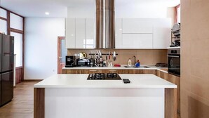 A modern kitchen with a central island, stainless steel appliances, and wooden cabinetry.