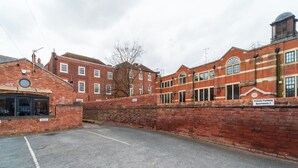 A brick building with a sign indicating 'Private Parking Apartment 2.' - Modern 2 En-Suite Bedrooms Worcester, Free Parking (Worcestershire)