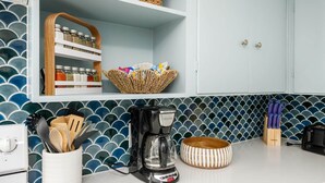 A kitchen with a coffee maker, utensils, a basket, and a toaster. - Salty Dog Beach House close to beach - Dog Friendly! (Pacific Beach)