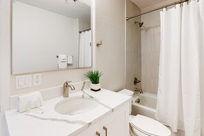 A modern bathroom with a large mirror, a sink, a toilet, and a shower area. - Chic dog-friendly condo with pool, central AC, washer/dryer, & grill (Tucson)