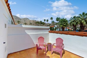 A balcony with two pink chairs and a small table, overlooking a mountainous landscape with palm trees. - Tennis Villa at La Quinta Resort with shared pool & spa, near hiking & golf (La Quinta)