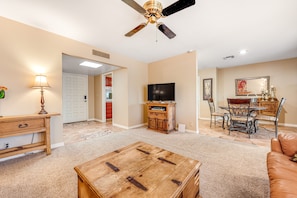 A spacious living room with a wooden coffee table, a ceiling fan, a television, and a dining area with chairs and a table. - Downtown Home w/Enclosed Yard, Gas Grill, Free WiFi, Central A/C, Washer/Dryer (Mesa)