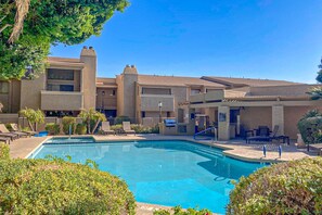 A hotel with a swimming pool, outdoor seating, and a covered patio area. - Sonoran Starlight condo with large backyard, pool and jacuzzi (Scottsdale)