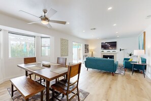 A modern living room with a dining area, a fireplace, and a television. - Views, tranquility, private pool and spa, outdoor kitchen (Palm Springs)