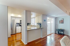 A modern kitchen with white cabinets, a stainless steel refrigerator, and a granite countertop. - Centrally located retreat with pool, Ping-Pong, balcony, full kitchen, W/D, & AC (Tempe)