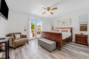 A bedroom with a bed, a bench, a sofa, and a TV. - Desert gem with private pool, enclosed yard, game room & fast WiFi -dog-friendly (Indio)