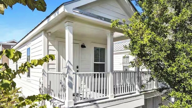 A two-story house with a covered porch and a small balcony. - The Pass Picture Book (Pass Christian)