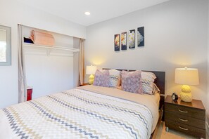 A neatly arranged bedroom with a bed, bedside lamps, a nightstand, and wall art. - Dreamy, dog-friendly home w/ private pool, spa & terrace - near El Paseo (Palm Desert)