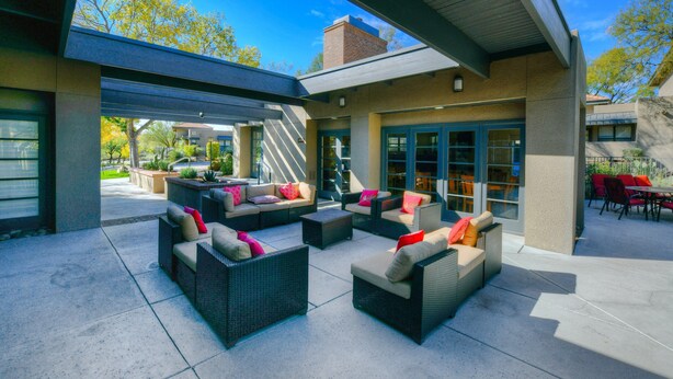 Un espace extérieur aménagé en terrasse, avec des meubles en osier et une partie couverte.