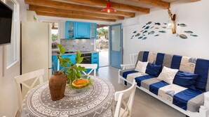 A cozy living room with a blue and white sofa, a wooden ceiling, and a kitchen with blue cabinets. - Villa Mare - OneBedroom Villa with Pool (Vrbnik)