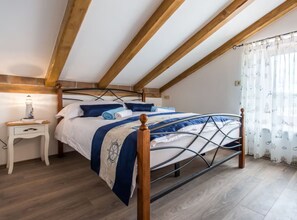 Una camera da letto con un letto, una testiera in legno, un comodino e una lampada.