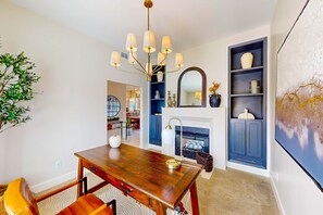 A dining area with a wooden table and chairs, a chandelier, a fireplace, and a bookshelf. - Dog-friendly home with mountain views, ample outdoor space, & washer/dryer (Tucson)