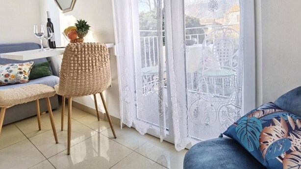 A cozy living room with a sofa, a small table with a pineapple, and a chair. - Monika Seaside Apartment - OneBedroom Apartment With Balcony (Kastel Luksic)