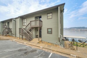 A row of light green buildings with balconies, a parking lot, and a waterfront view. - Easy-Access Lake Hamilton Condo w/ Fireworks View (Lake Hamilton)
