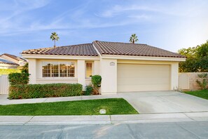 A single-story house with a tiled roof, a garage, and a well-maintained lawn. - Dog-friendly desert retreat with lovely pool & spa - minutes to Tennis Garden (Palm Desert)