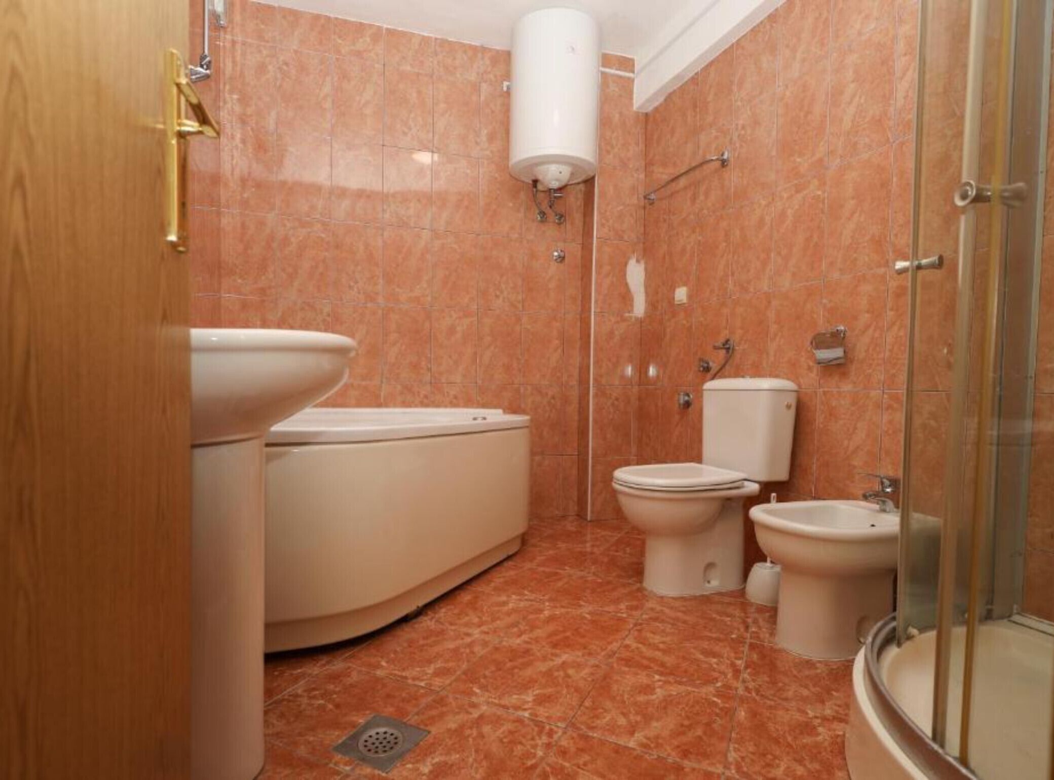 Une salle de bain équipée de toilettes, d’un bidet et d’une douche.