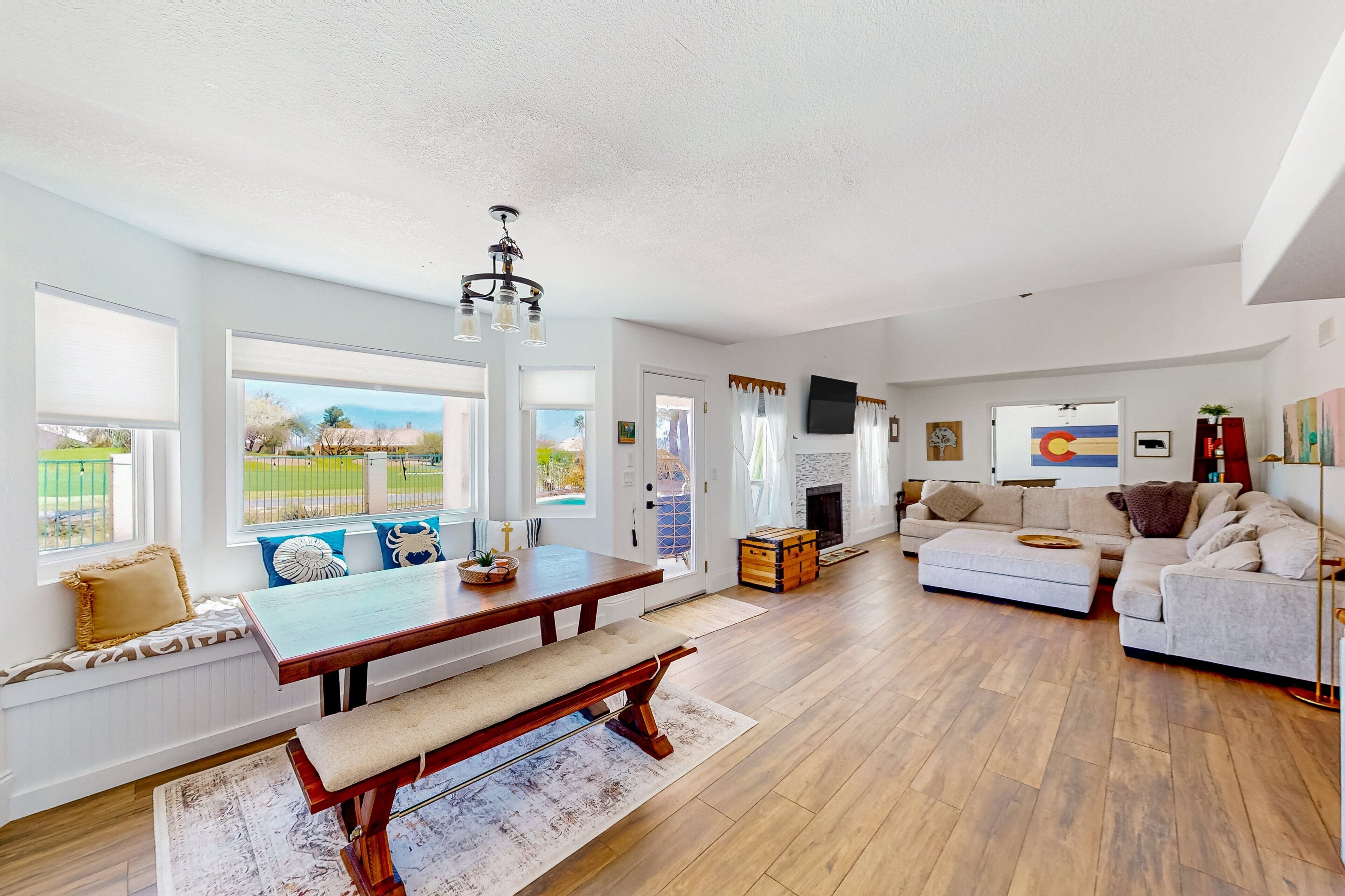 A spacious living room with a wooden bench, a sofa, and a dining table.