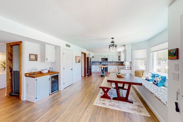 A spacious kitchen with wooden flooring, white cabinets, and a central island. - Golf-course-front home with private pool, spa, terrace & mountain view (Oro Valley)