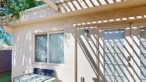 A small, single-room house with a bed, a table, and a window. - Spacious townhome with movie room, patios, pool, & home office (Scottsdale)
