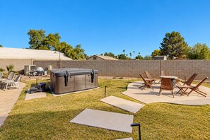 A backyard with a hot tub, outdoor furniture, and a barbecue area. - Charming Chandler retreat with pool, guest house, pickleball and putting green! (Chandler)