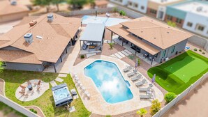 Ein Wohngebiet mit Schwimmbad, Terrassenmöbeln und einem Golfplatz.